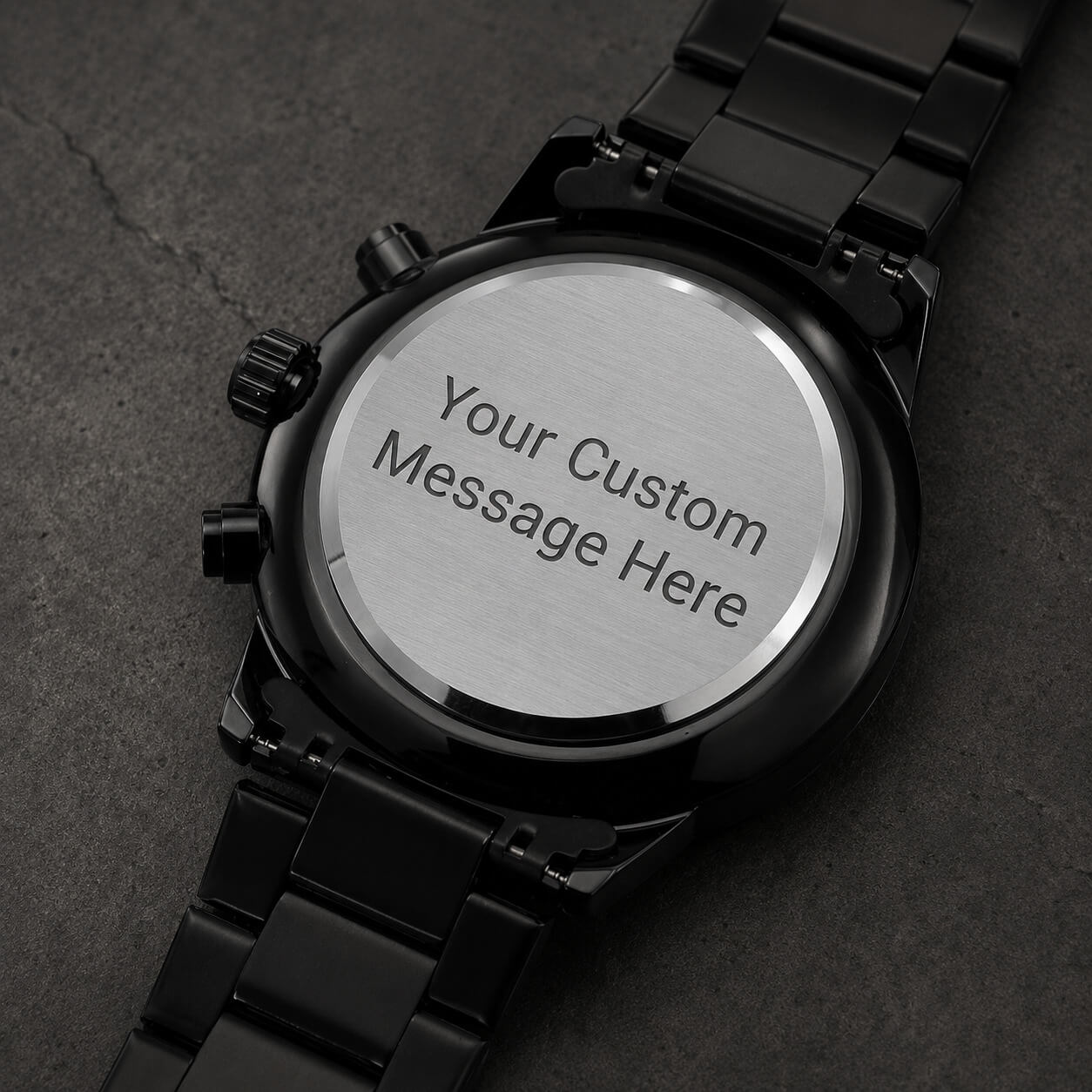 Back view of personalized engraved black chronograph watch showing a custom message