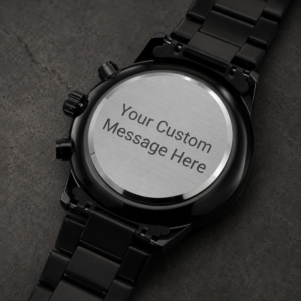 Back view of personalized engraved black chronograph watch showing a custom message