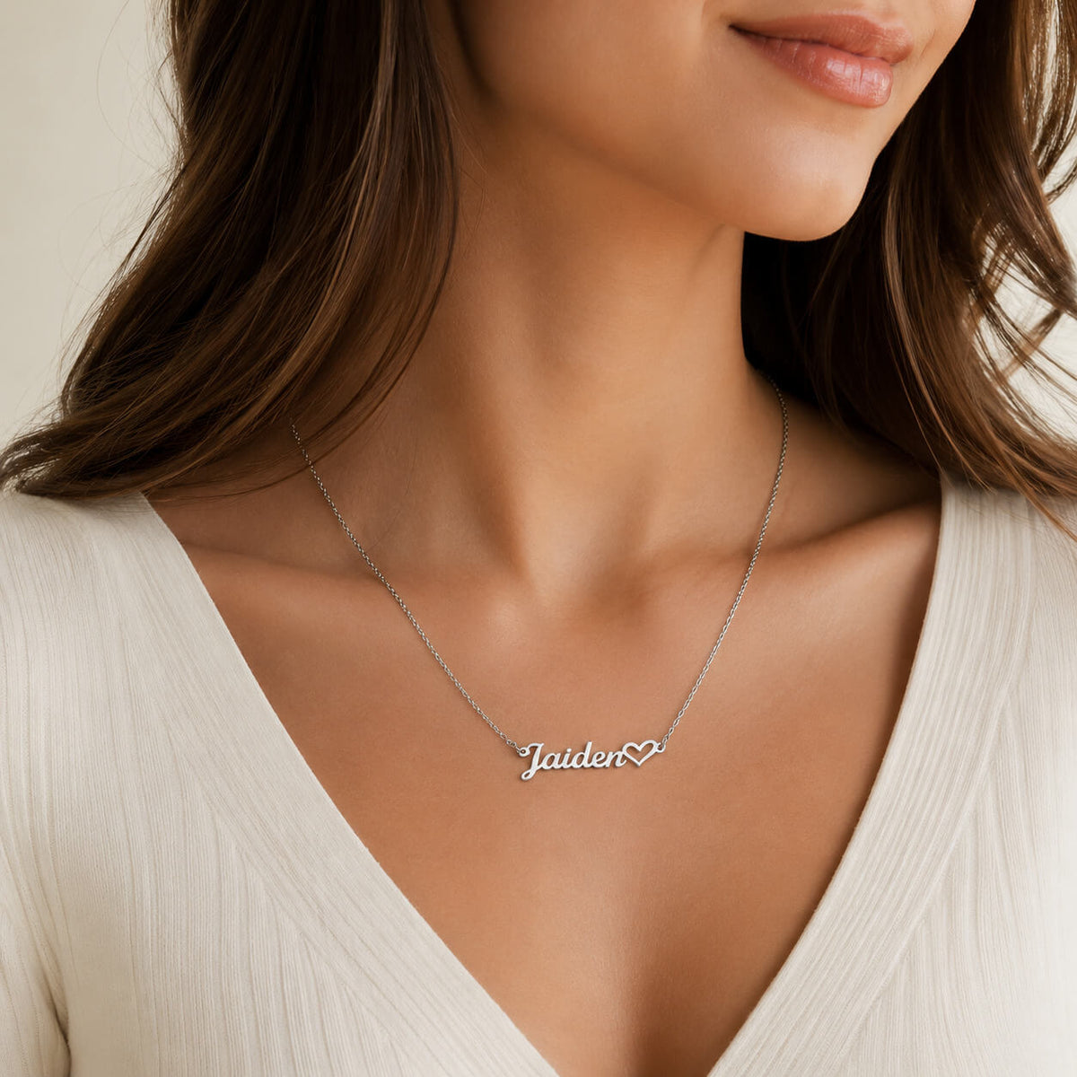 Personalized heart name necklace in silver worn by a woman