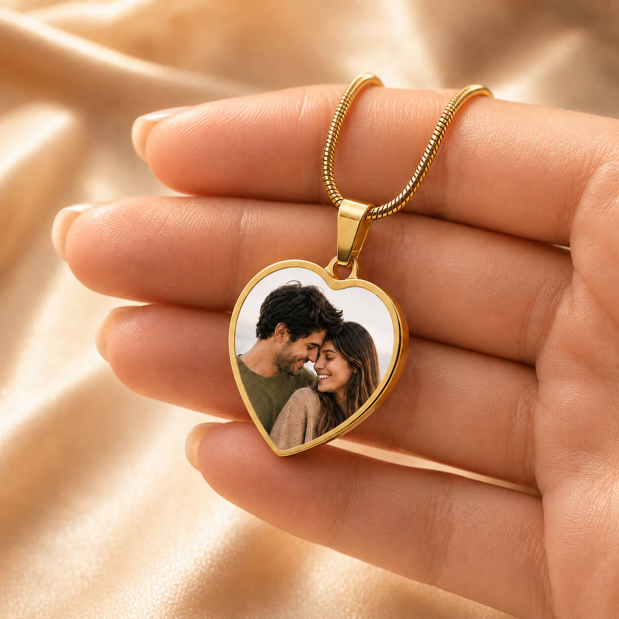 Personalized heart photo necklace in gold held in hand