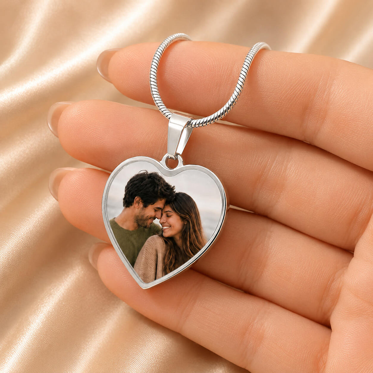 Personalized heart photo necklace in silver held in hand