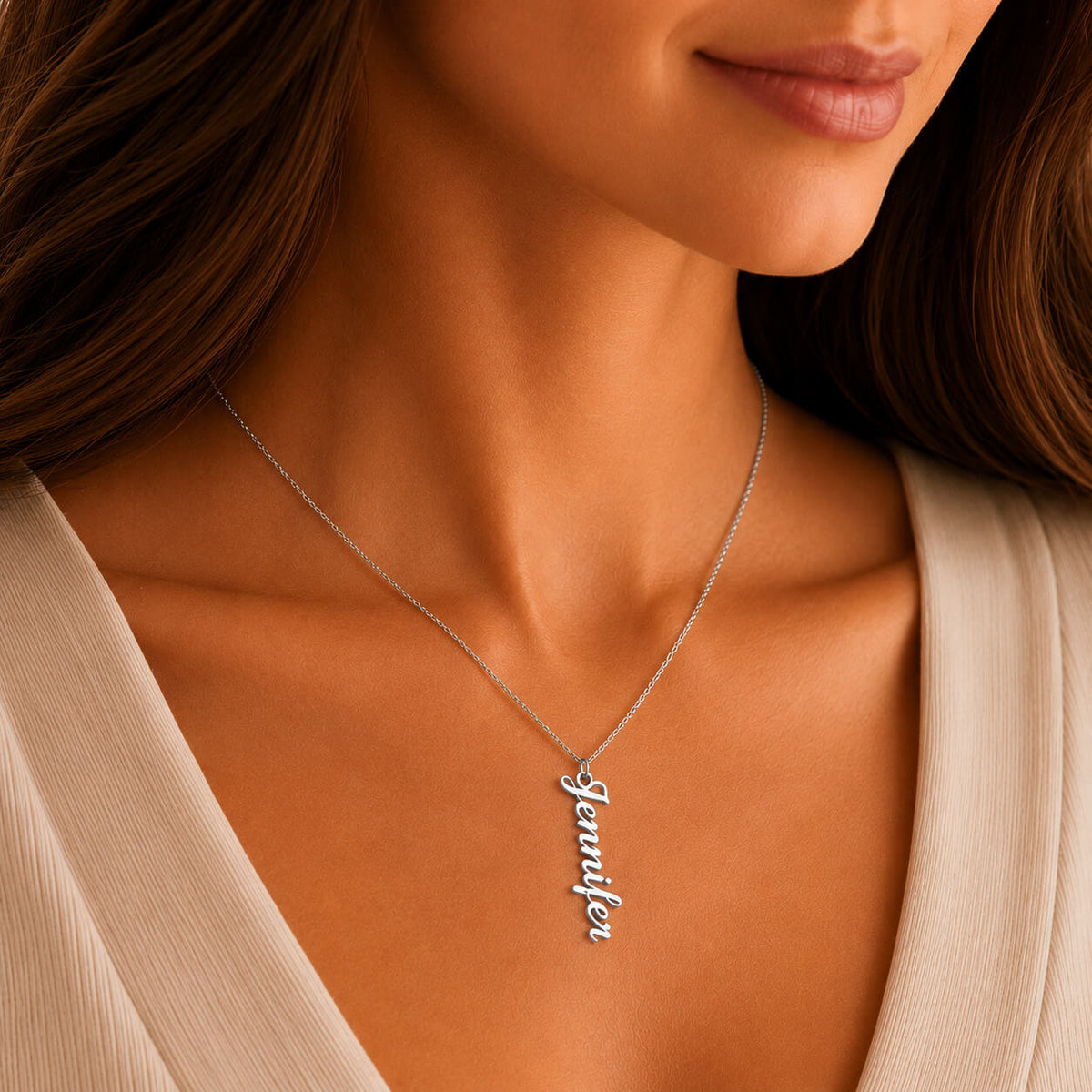 Close-up of personalized vertical name necklace in silver worn by a woman
