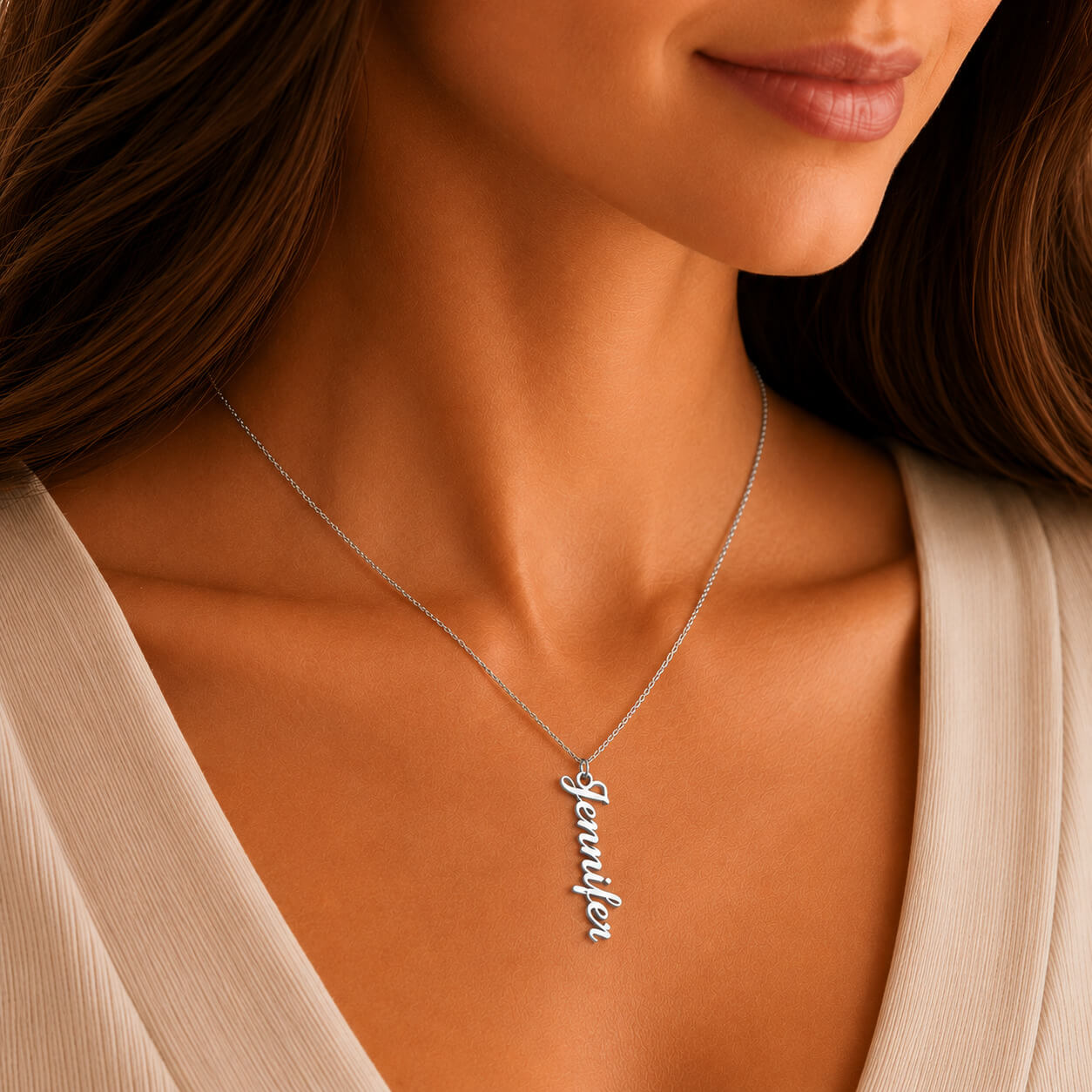 Close-up of personalized vertical name necklace in silver worn by a woman